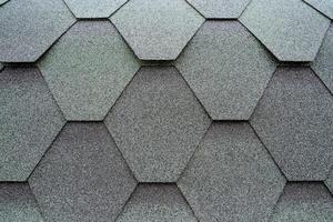 Roofing material on the roof close-up, tiles are the shape of a diamond, the texture of the material is covered with resin, bitumen with sand spraying of the protection layer. photo