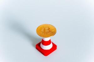 An abstract shot of a bitcoin coin on a white background and a road sign.growing cryptocurrency market, Electronic money that has no equivalent in paper money. photo