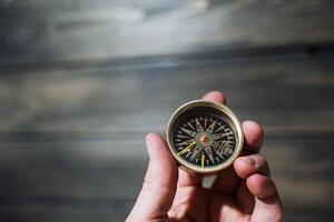 Antique compass in hand. a device that facilitates travel. Orientation to the magnetic poles of the Earth and the cardinal points. photo