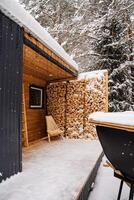 Dressing room with firewood. Garden chaise longue made of wood. Garden chair for outdoor seating, Logs.Stacked firewood in the backyard. photo