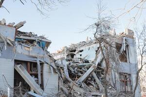 The ruins of the building after the blows of heavy equipment. The house turned into a pile of stones, broken factory walls, disaster, natural disaster. photo