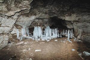 cueva hielo carámbanos karst grieta en montaña oscuro sótano subterráneo congelado estalagmitas espeleología Roca paredes un peligroso viaje foto