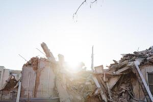 el destrucción de el edificio en el rayos de el Mañana sol, el restos de un Departamento edificio, el tragedia destruido el casa a el suelo, el catástrofe en el ciudad, el natural desastre. foto