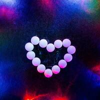 Abstract photo. The figure is lined with candy. A heart of mentos in the light of bright lights. Love. Valentine's Day photo