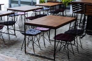 el interior de un al aire libre establecimiento en el desván estilo, un verano restaurante en el calle, un vacío mesa para servicio, un de madera encimera foto