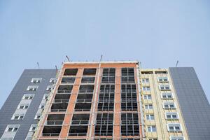 View of the construction of a high-rise building. Brick fasade. Profile made of aluminum for windows on the balcony. Insulate the walls with mineral wool. Keeping the house warm. photo