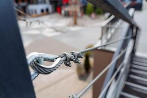 metal cable, fijación el cable a el barandilla con pernos, fuerte metal barandillas de el escalera hecho de trenzado cable. foto