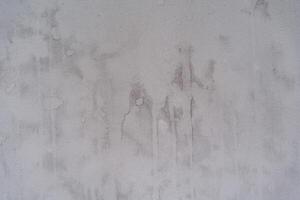 A white wall with stains. The wall in front of the putty. Renovation of living quarters.Textured surface, abstract drawing. Wet stains on the wall, stains photo