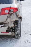 The car is standing on the road rear bumper accident, the wing of the car is broken, the winter track. photo