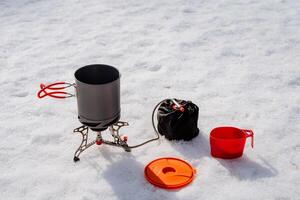 vajilla en un caminata parte superior vista, un conjunto de ligero turista utensilios, un gas quemador Cocinando comida en un cacerola, un aluminio maceta con manejas, almuerzo en el bosque foto