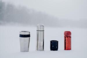 A set of thermoses of different sizes and shapes. Dishes for hot drinks. Tourist tableware made of metal. photo