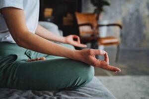 The side view of the hand in the meditation pose fingers folded into the rank of mudru. A young woman practices yoga at home, Zen practice, asana tranquility lotus pose. photo