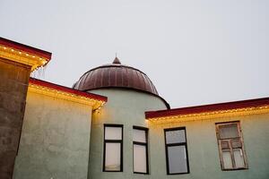 Interior shot of a building in the city center. The building is of unusual construction. Round roof. On the facade of the building there is a garland. photo