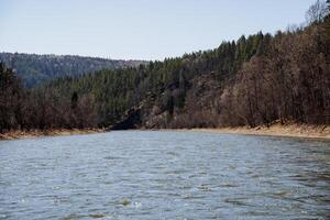 The river flows through a remote area without people, Spring is an empty forest with no leaves, taiga Russia is the Southern Urals, spring flood. photo