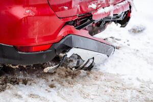 Broken car bumper. Accident on the road. The red car has a broken rear trunk. The plastic in the car cracked. photo