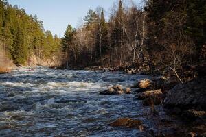 Turbulent flow on a mountain river, stones in the riverbed, rafting on rapids, kayakers rafting on the river, canyon rocky shores, Aigir Bashkortostan Russia photo