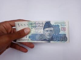 Pakistani 1000 Note hold in hand, Isolated on white background. photo