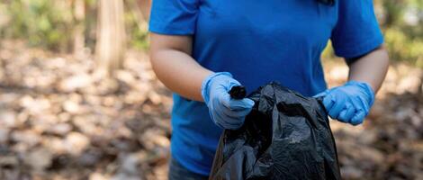 separando residuos a refrescar el problema de ambiental contaminación y global calentamiento, el plastico desperdiciar, cuidado para naturaleza. voluntario concepto que lleva basura pantalones coleccionar el basura foto