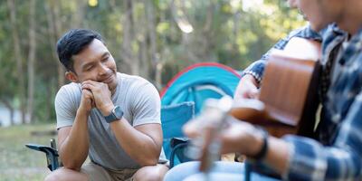 Happy Asian male gay couple on camping together in a forest. romantic vocation trip. lgbt concept photo
