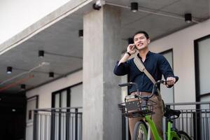 empresario y bicicleta en ciudad a trabajo con eco simpático transporte. bicicleta y contento empresario profesional hablando, Hablando y teléfono discusión mientras en en urbano calle foto