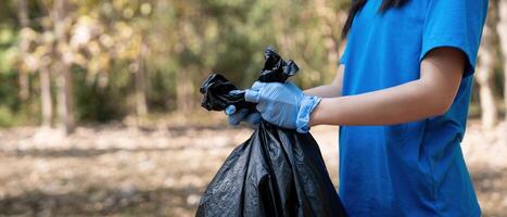 Separating waste to freshen the problem of environmental pollution and global warming, plastic waste, care for nature. Volunteer concept carrying garbage bags collecting the garbage photo