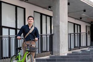 Eco friendly, Happy lifestyle asian young businessman ride bicycle go to office work at city street with bicycle in morning photo