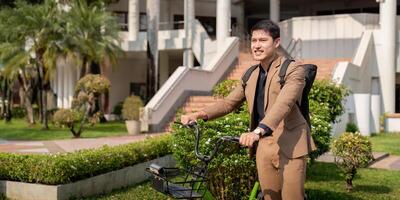 Asian businessman in a suit is riding a bicycle on the city streets for his morning commute to work. Eco transportation concept, sustainable lifestyle concept photo