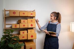 puesta en marcha SME pequeño negocio empresario SME o Lanza libre asiático mujer utilizando un ordenador portátil con caja, joven éxito asiático mujer en línea márketing paquete caja y entrega concepto foto