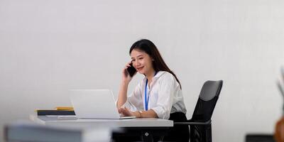 Happy confident businesswoman talking on the phone. Smiling female business person talking work using talking on the phone at office sitting at desk photo