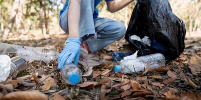 separando residuos a refrescar el problema de ambiental contaminación y global calentamiento, el plastico desperdiciar, cuidado para naturaleza. voluntario concepto que lleva basura pantalones coleccionar el basura foto