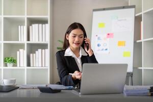 Happy confident businesswoman talking on the phone. Smiling female business person talking work using talking on the phone at office sitting at desk photo