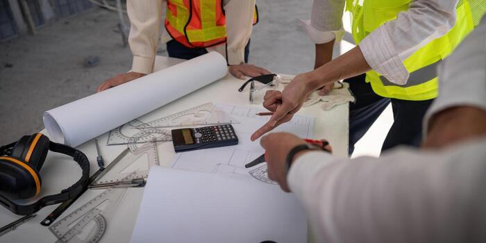 Construction concept of Engineer or architect meeting for project working with partner and engineering tools on building and blueprint in working site photo