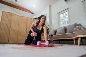 Happy fat overweight woman wearing sportswear doing fit exercise with dumbbells in living room at home. Workout sport, fitness and body concept photo