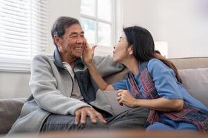 Happy mature husband and wife sit rest on comfortable sofa in living room enjoy talking, smiling elderly couple relax on couch at home chat speak laugh on leisure weekend photo