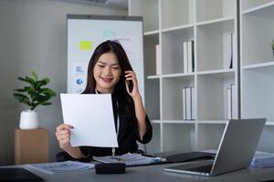 Happy confident businesswoman talking on the phone. Smiling female business person talking work using talking on the phone at office sitting at desk photo