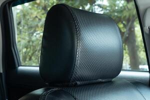 A black seat headrest in the car. Car leather headrest. photo