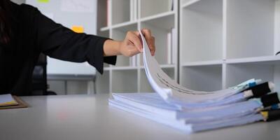 Business accounting woman counting on calculator working on financial document in hands closeup. Bookkeeping concept photo