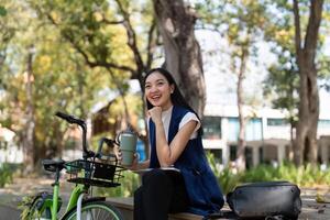 Businesswoman ride bicycle sit outside working Entrepreneur commuting by cycling reduce carbon footprint. Bike to work eco friendly alternative vehicle green energy photo