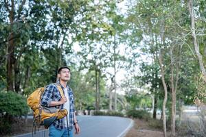 hombre asiático de viaje con tienda cámping en montaña parte superior al aire libre aventuras estilo de vida excursionismo activo verano vacaciones foto