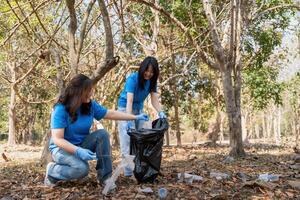 Volunteer collecting plastic trash in the forest. The concept of environmental conservation. Global environmental pollution. Cleaning the forest photo