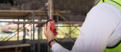 Engineer checking and inspection house project via walkie talkie before delivered to the homeowner. Concept of construction and inspection work photo