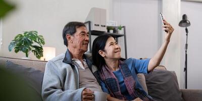 Happy old couple elderly taking selfie on cellphone, senior mature spouses wife and husband laughing holding phone make self portrait on smartphone camera photo