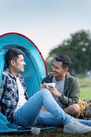 contento asiático masculino gay Pareja en cámping juntos en un bosque. romántico vocación viaje. lgbt concepto foto