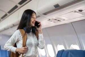 Alone Asian woman passenger traveling by plane. happy traveler on board. Solo travel concept photo