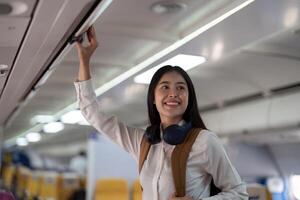 Alone Asian woman passenger traveling by plane. happy traveler on board. Solo travel concept photo