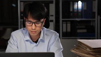 Exhausted Asian young businessman worker working on table in office. video