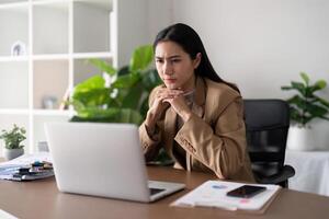 Eco friendly, businesswoman young asian stress in working on laptop while sitting at home office, green room area. sustainable lifestyle concept photo