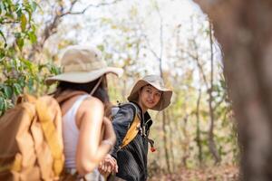 Lovely couple lesbian woman with backpack hiking in nature. Loving LGBT romantic moment in mountains photo