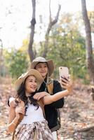 Lovely couple lesbian woman with backpack take a selfie while hiking in nature. Loving LGBT romantic moment in mountains photo