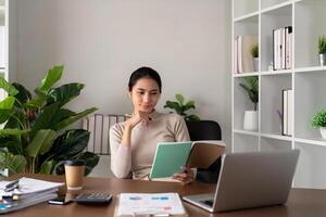 Young woman asian reading a book. Business, freelance, Concept of rest, relaxation, green room area, sustainable lifestyle photo